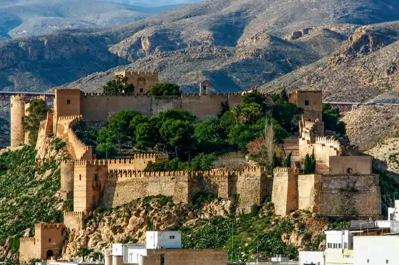 Alcazaba w Almerii na wzgórzu z murami, wieżami i drzewami w środku