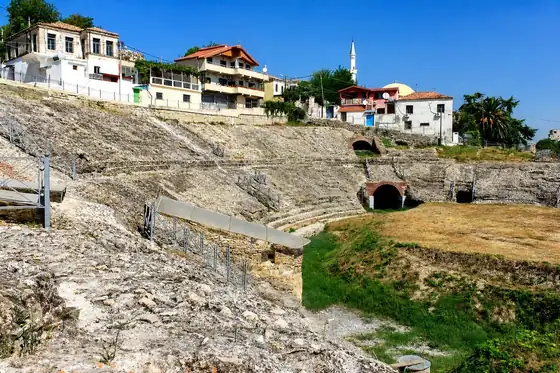 Amfiteatr rzymski w Durrës z widocznymi kamiennymi łukami i zabudową nad ruinami