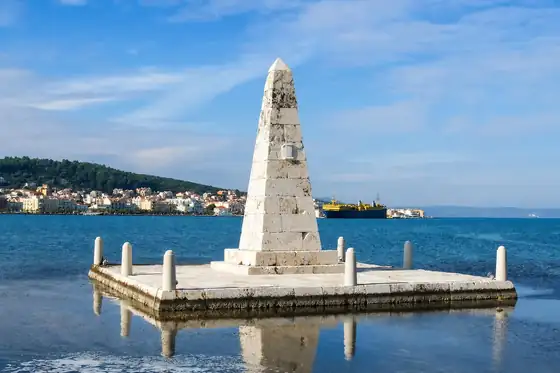 Argostoli i żółwie w porcie w Kefalonii, obelisk na platformie nad wodą