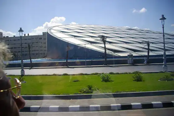 Biblioteka Aleksandryjska w Aleksandrii z widocznym okrągłym dachem i latarniami przy ulicy.
