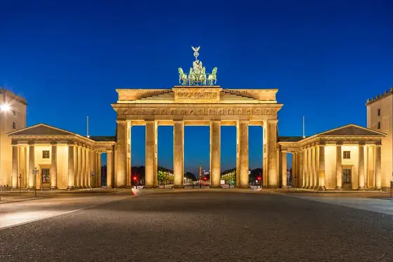 Brama Brandenburska w Berlinie nocą, z podświetlonymi kolumnami i kwadrygą