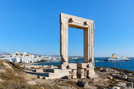 Brama Portara na Naxos z widokiem na miasto, port i prom na morzu