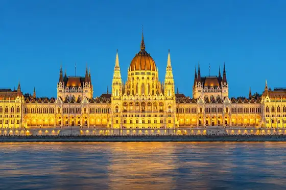 Budynek Parlamentu w Budapeszcie nad brzegiem Dunaju o zmierzchu.