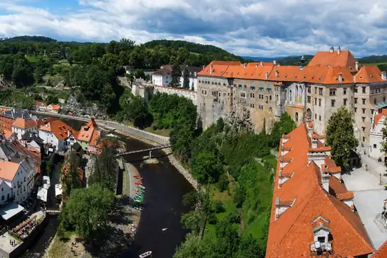 Czeski Krumlov w regionie Szumawy nad rzeką, z zamkiem i dachami domów