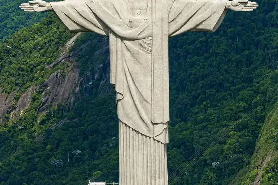 Figura Chrystusa Zbawiciela na Corcovado w Rio de Janeiro na tle zielonych zboczy.