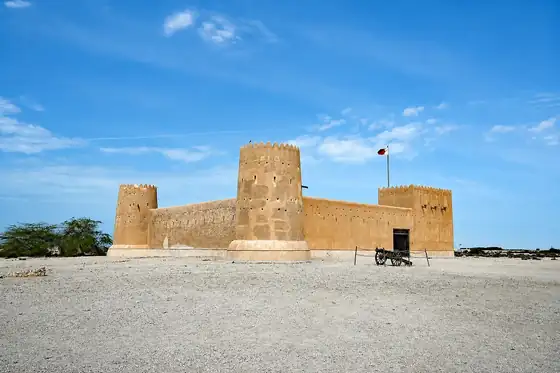 Fort Al Zubarah w Al Zubarah z wieżami i flagą na tle nieba
