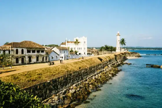 Fort w Galle nad brzegiem oceanu, z murami, latarnią i zabudową.