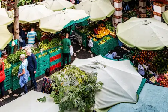 Mercado dos Lavradores w Funchal z ladami owoców pod białymi parasolami
