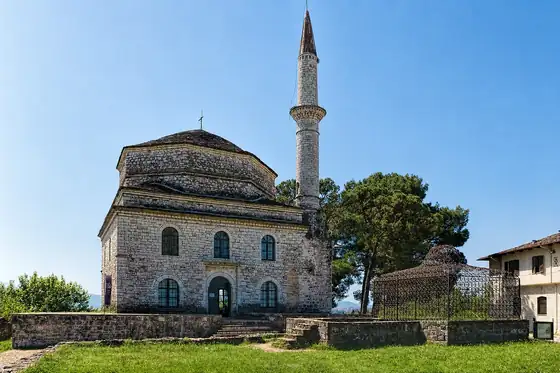 Jeziora i miasto Janina w Janinie: kamienny meczet z minaretem i drzewami