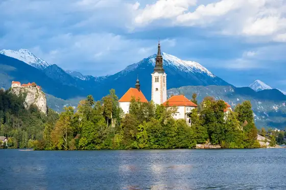 Jezioro Bled w Bled, wyspa z kościołem, drzewa, góry i woda
