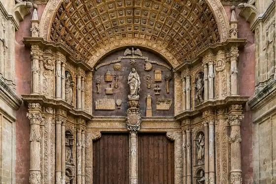 Katedra La Seu w Palmie z ozdobnym portalem i rzeźbami nad drewnianymi drzwiami