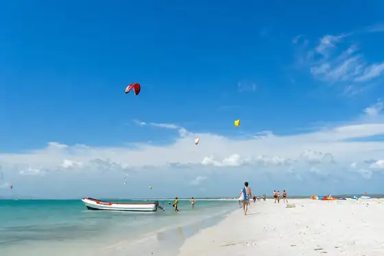 Kitesurfing na Coche na plaży z łodzią, ludźmi i latawcami nad wodą