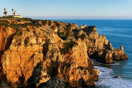 Klify Ponta da Piedade w Lagos z latarnią i oceanem w tle