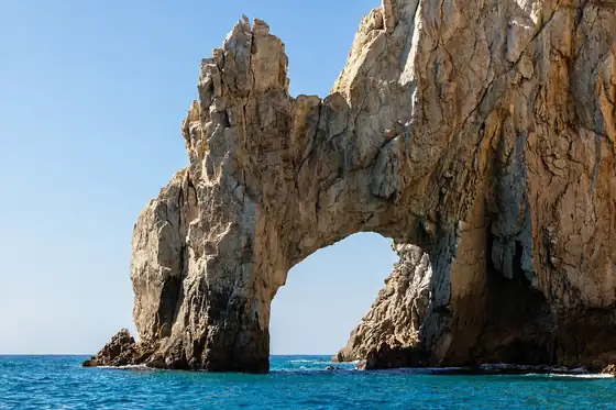 Łuk skalny El Arco w Cabo San Lucas nad błękitnym morzem i skalnym brzegiem