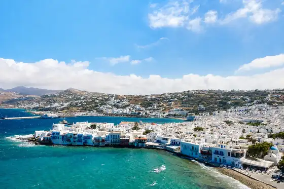 Mała Wenecja i wiatraki na Mykonos nad zatoką z białą zabudową.