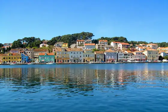 Mali Lošinj i port, portowe domy nad wodą na tle wzgórza na Wyspie Cres
