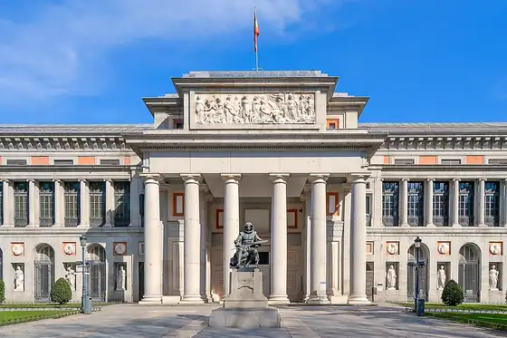 Muzeum Prado w Madrycie z kolumnowym wejściem i pomnikiem przed fasadą