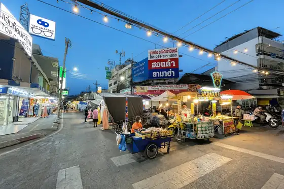 Nocny targ w Hua Hin z kramami, oświetleniem i przechodniami przy ulicy