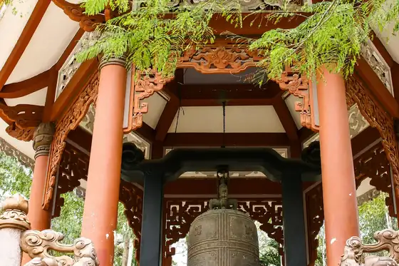 Pagoda Long Son w Nha Trang z dzwonem pod drewnianym dachem i czerwonymi kolumnami