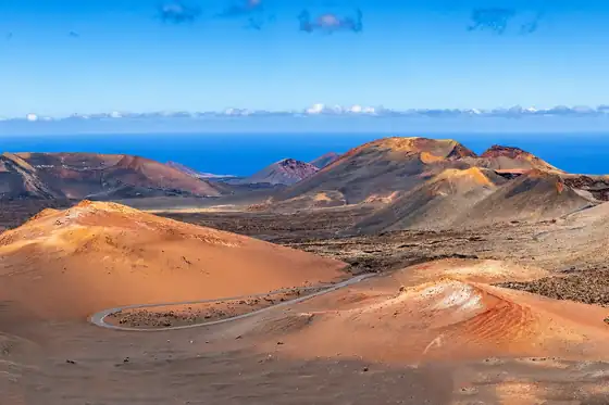 Park Narodowy Timanfaya w Yaiza na Lanzarote: wulkaniczne wzgórza i ocean w tle
