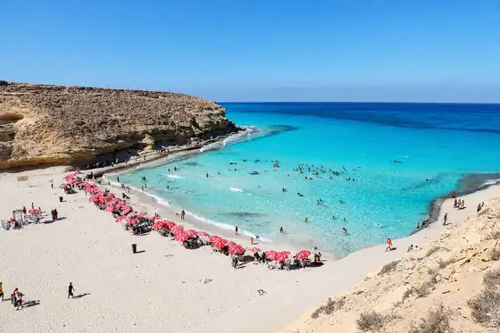 Plaża Agiba w Marsa Matrouh z zatoką, plażą i skałami nad morzem