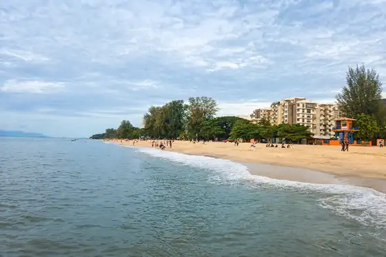 Plaża Batu Ferringhi i nocny targ w Batu Ferringhi, z piaskiem, morzem i zabudową przy brzegu.