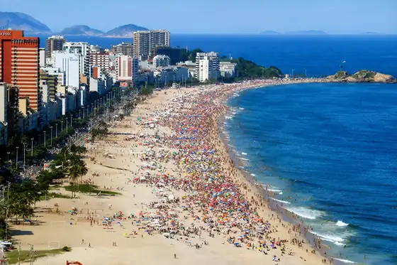 Plaża Ipanema w Rio de Janeiro z tłumem ludzi, wieżowcami i oceanem