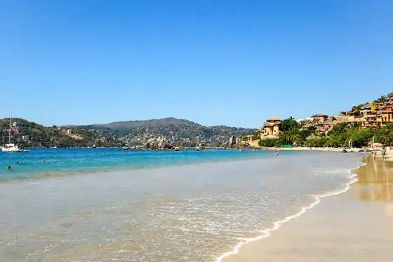 Plaża La Ropa w Zihuatanejo z piaszczystym brzegiem, morzem i wzgórzami w tle