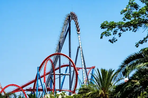 PortAventura w Salou: wagoniki na wysokiej pętli rollercoastera nad palmami