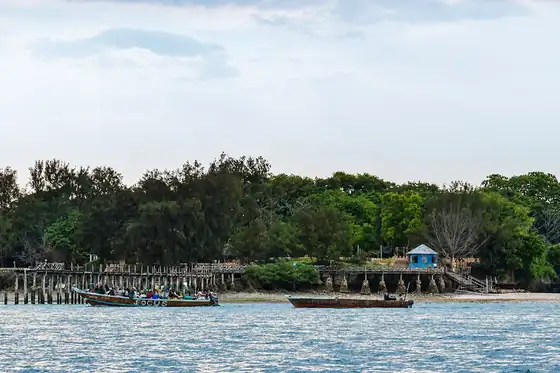 Prison Island z żółwiami olbrzymimi na Zanzibarze, pomost i łodzie przy brzegu