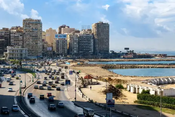 Promenada Corniche nad morzem w Aleksandrii z jezdnią, zabudową i linią brzegu
