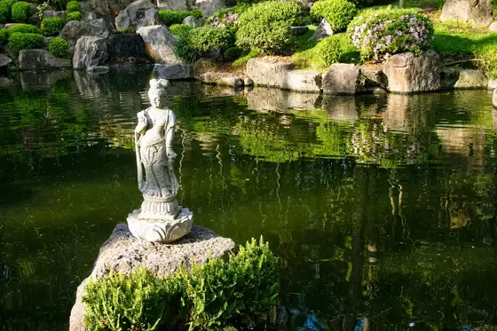 Rafa Japanese Garden w Akabie, rzeźba na kamieniu nad wodą i zieleń przy brzegu