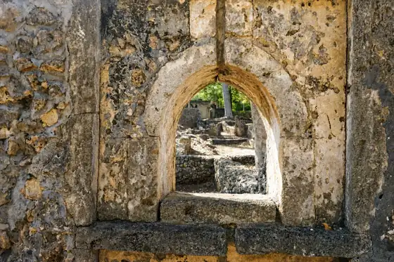 Ruiny miasta Gede w Watamu, kamienny otwór w ścianie i fragmenty murów