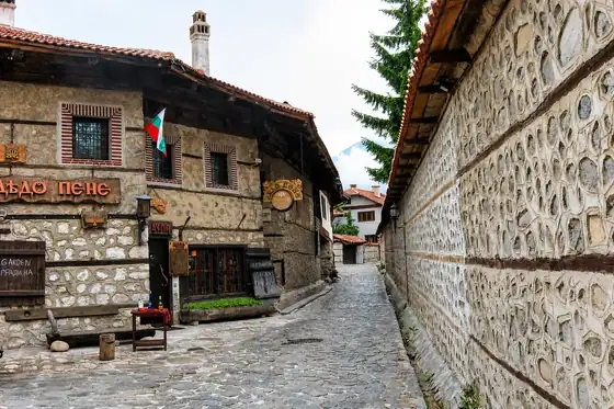 Stare miasto Bansko w Bułgarii, kamienne domy przy wąskiej uliczce w regionie Pirin