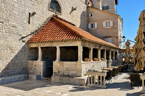 Stare miasto Trogir w Trogirze z kamiennym portykiem i czerwonym dachem