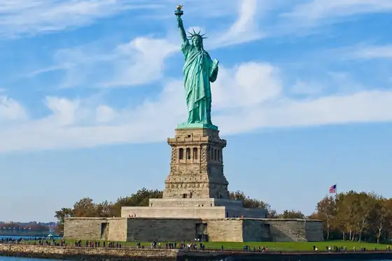 Statua Wolności i Ellis Island na tle nieba w Nowym Jorku.