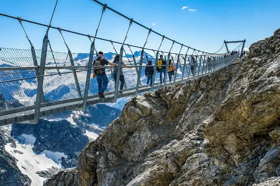 Most Cliff Walk przy Titlis w Engelbergu nad skalnym urwiskiem i ośnieżonymi górami