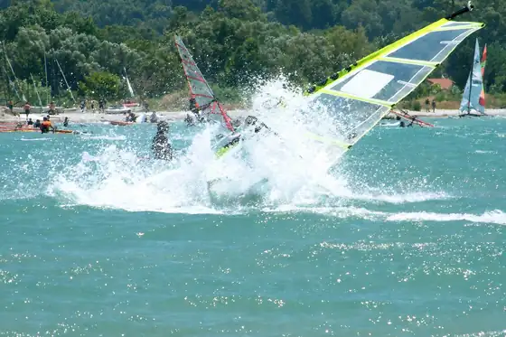 Windsurfing w Vassiliki na Lefkadzie, żagiel przecina wodę przy brzegu