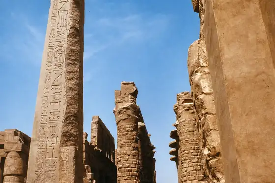 Świątynia Karnak w Luksorze z kamiennymi kolumnami i pylonami pod błękitnym niebem