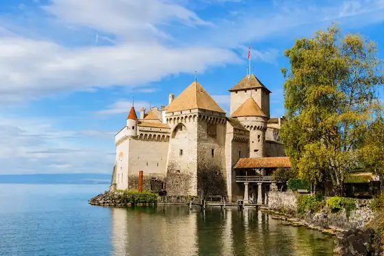Zamek Chillon w Montreux nad brzegiem Jeziora Genewskiego i przy drzewie