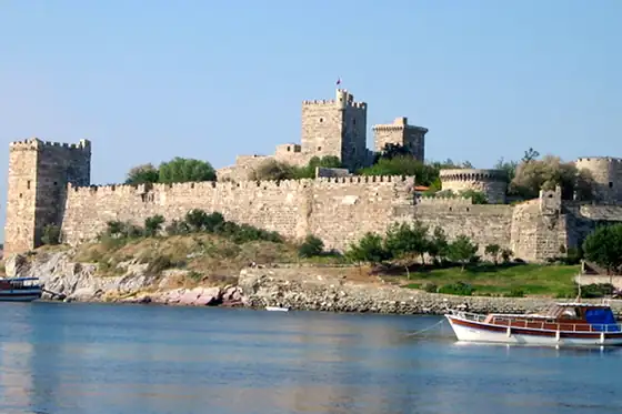 Zamek św. Piotra i Muzeum Archeologii Podwodnej w Bodrum nad wodą z łodzią