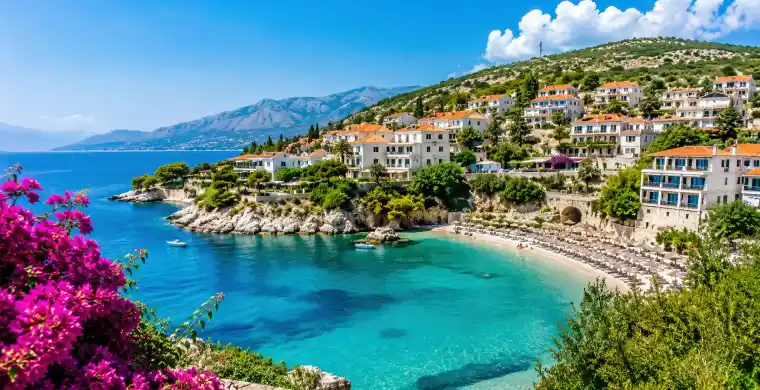 Turkusowa zatoka i kwitnące bugenwille na wybrzeżu, Albania