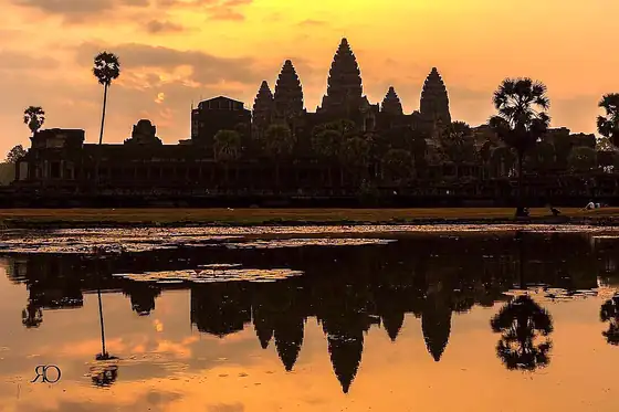Angkor Wat w Kambodży odbija się w wodzie o zachodzie słońca
