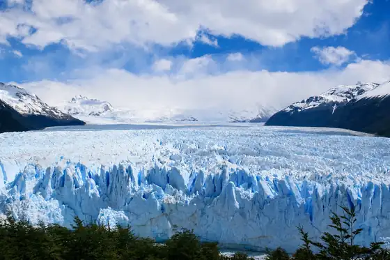 Lodowiec Perito Moreno w Argentynie z taflą lodu, górami i chmurami w tle