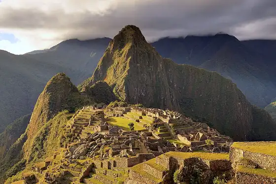 Machu Picchu w Peru na zboczu górskim, wśród kamiennych ruin i stromych szczytów.