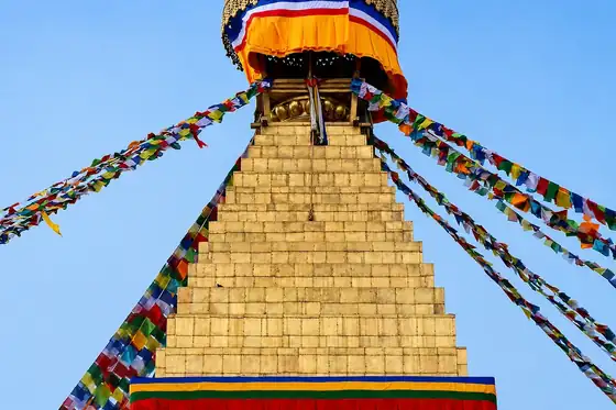 Stupa Boudhanath w Katmandu, Nepal, z kolorowymi flagami modlitewnymi na tle nieba