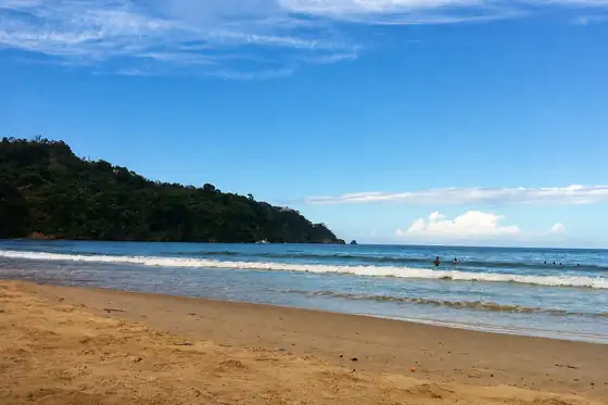 Zatoka Maracas w Trynidad i Tobago, plaża, morze i kilka osób w wodzie.